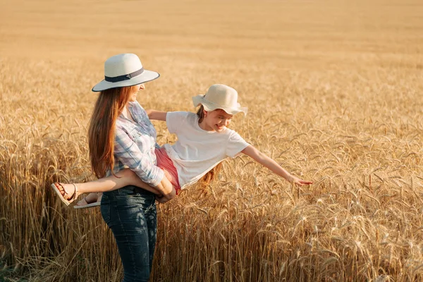 Agricultora con sombrero sostiene a su hijo en sus brazos. —  Fotos de Stock