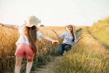 Şapkalı mutlu çiftçi anne mutlu koşan kızını bekliyor..
