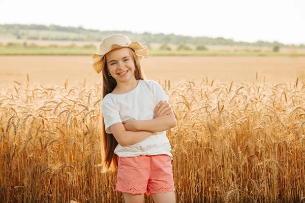 Adorable niña feliz con sombrero en el campo de trigo —  Fotos de Stock