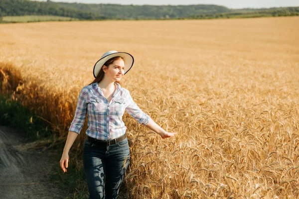 Una buena mujer agricultora inspecciona el campo de cereales. —  Fotos de Stock