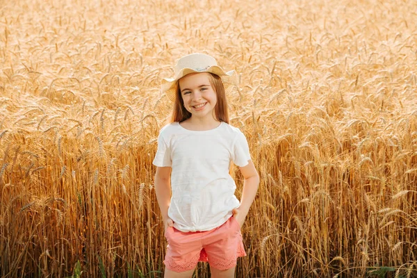Kislány gazdák lánya a búzamezőn nézi kamera és mosolyog vonzóan. — Stock Fotó