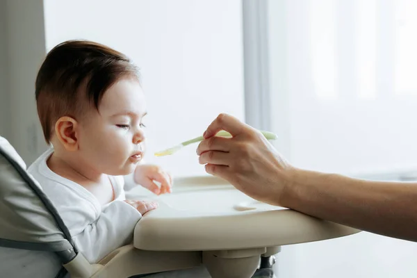 Ritratto di un bambino dolce, nutrito con cibo per bambini da un cucchiaio — Foto Stock