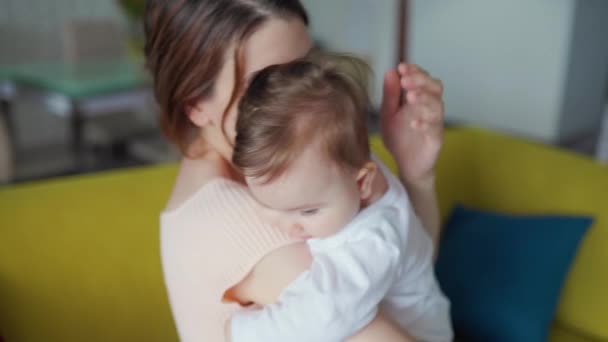 Jovem mãe e seu bebê, mulher abraça seu filho ou adorável menina. — Vídeo de Stock