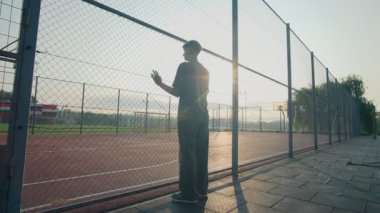 Genç bir çocuk boş bir okul basketbol sahasının çitlerinden bakıyor. Sessizliğe kapılmış, gençliğin, yalnızlığın ve düşüncenin hikayesini yansıtıyor..