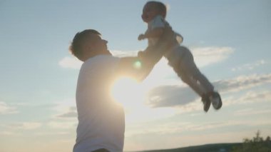 Baba gün batımında oğlunu neşeyle havaya kaldırır, hem güler hem de bağ kurar. Sevgi, mutluluk, özgürlük ve oyunculuk dolu iç açıcı bir an..