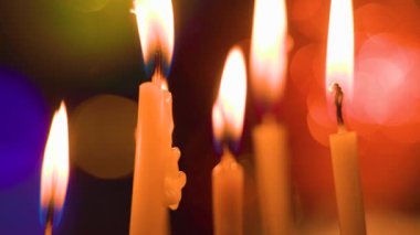 Kilisenin mumlarından biri akarken ve damlarken mumlar yanıyor. Mumların sakin yanması, onlara bakan herkesi büyülüyor. Seçilene odaklan.