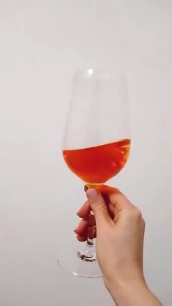 여성 손에 와인 잔에 든 Aperol Spritz Cocktail. 길고 지루 한 음료. 느린 동작 — 비디오