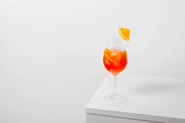 Aperol Spritz Cocktail în sticlă de vin cu gheață și felie de portocale pe fundal alb. Conceptul creativ minim — Fotografie, imagine de stoc