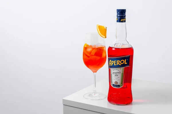 Lugansk, Ukraine - 29 mars 2021 : Aperol Spritz Cocktail. Aperol en bouteille et verre à vin avec glace sur fond blanc. — Photo
