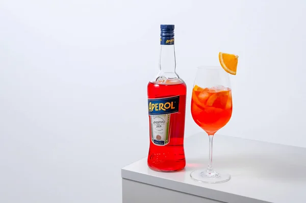 Lugansk, Ucrânia - 29 de março de 2021: Aperol Spritz Cocktail. Aperol em garrafa e copo de vinho com gelo sobre fundo branco. — Fotografia de Stock