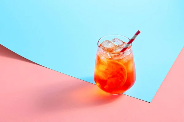 Aperol Spritz Cocktail en verre avec glace et tranche d'orange sur fond coloré à la mode. Concept minimal créatif — Photo