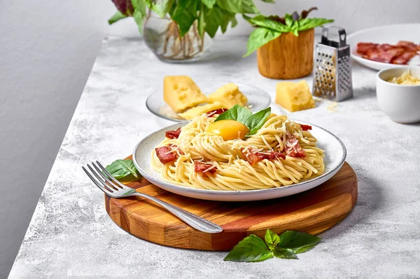Pasta tradicional italiana Carbonara con tocino, queso y yema de huevo sobre fondo claro Fotos de stock