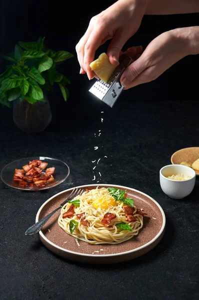 Pasta tradicional italiana Carbonara con tocino, queso y yema de huevo. Espaguetis espolvoreado queso en la placa. Imagen de archivo