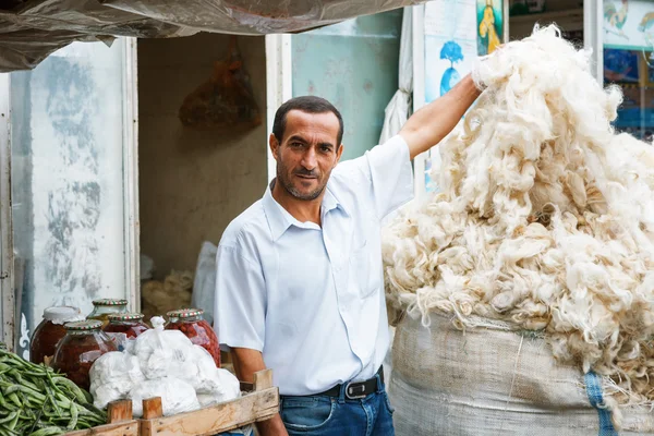 Sheki, Azerbaijan - 20 Temmuz 2015: erkek satıcı koyun yünü kameraya bakarak portresi