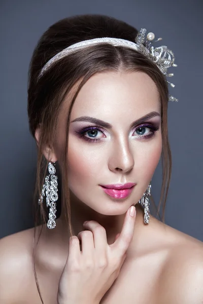 Beautiful young bride with wedding makeup  on studio background — Stock Photo, Image