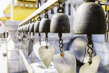 Dilek güneş ışığı altında birçok altın Budist zillerle