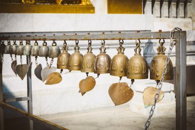 Dilek güneş ışığı altında birçok altın Budist zillerle