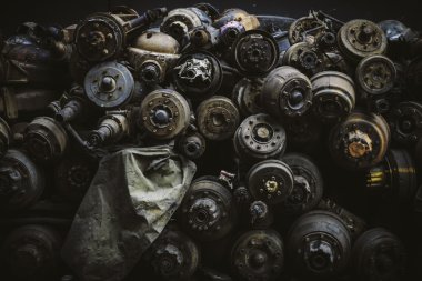 Hurda bahçesinde paslı eski akslar yığını