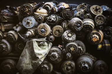 Hurda bahçesinde paslı eski akslar yığını