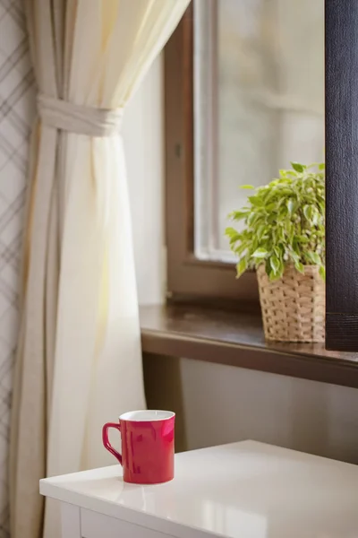 Beker voor koffie tegen een raam — Stockfoto