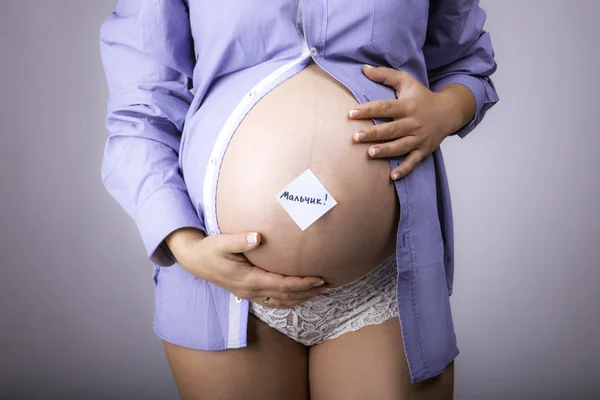 Kobieta w ciąży z naklejki chłopiec słowa pisanego w języku rosyjskim — Zdjęcie stockowe