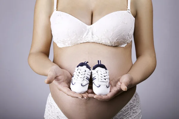 Pregnant Woman holding little shoes — Stock Photo, Image