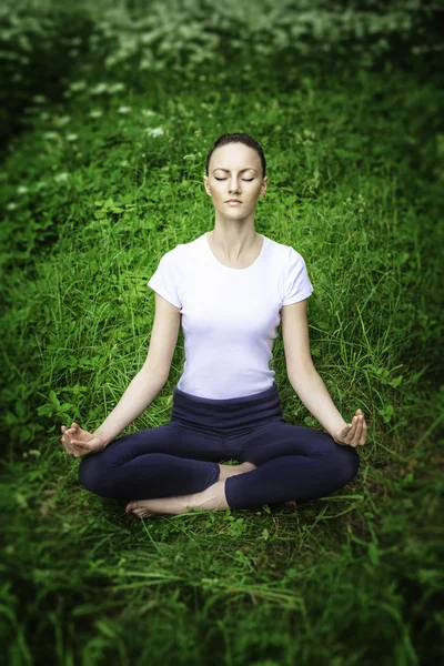 Jeune fille pratiquant le yoga dans une forêt — Photo