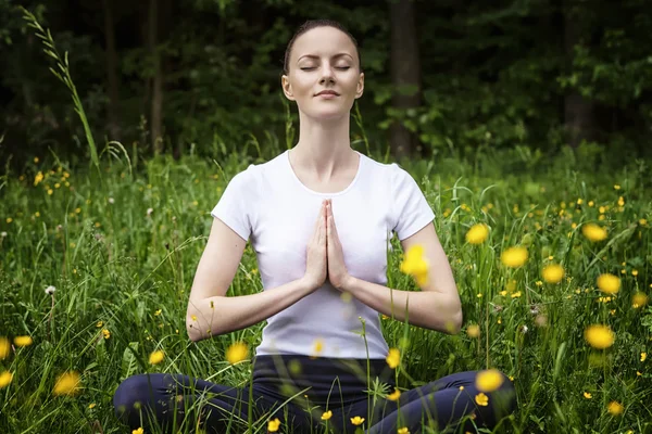Jeune fille pratiquant le yoga dans une forêt — Photo