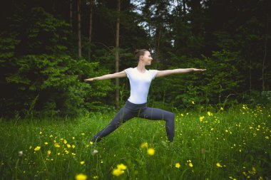 Güzel sportif genç kadın Virabhadrasana çalışma spor giyim uygun