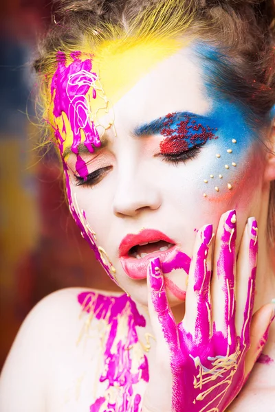 Portrait of beautiful young woman with paint on face — Stock Photo, Image