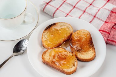 Limon reçelli ekmek, boş bardak, çay kaşığı ve peçete.