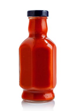 Parlak beyaz arka planda domates soslu cam şişe.