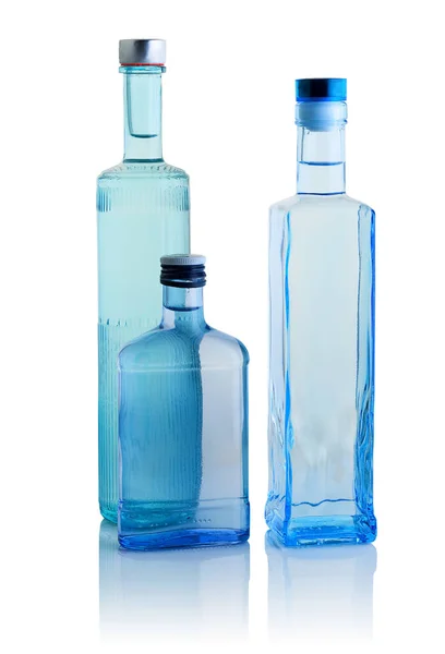 Three Bottles Colored Transparent Glass Different Shapes Vodka White Background — Stock Photo, Image