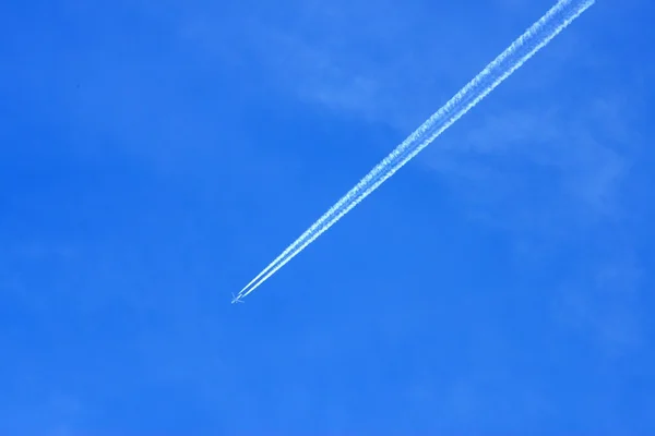 Rastreamento de condensação deixado de um avião no céu azul — Fotografia de Stock