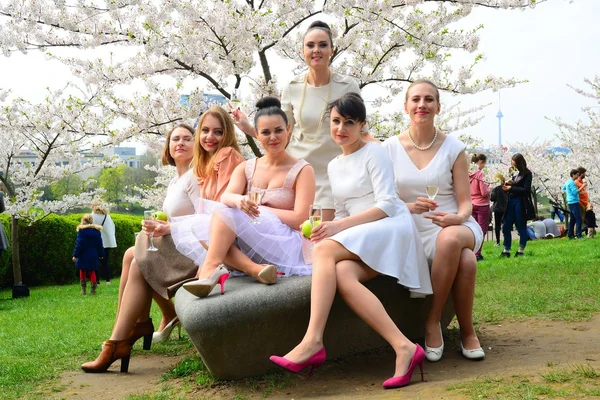 Girls with champagne celebrating in sakura's garden. — Stock Photo, Image