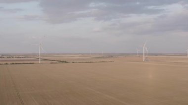 Hava görüşünden rüzgar türbinleri. Yenilenebilir enerji. Gün batımında yel değirmenleri ve güzel manzaralar. Hava görüntüsü. 4k video