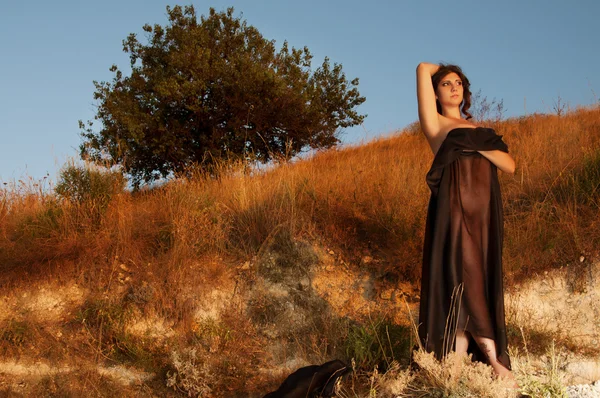 A fekete ruhával naplementére barna nő — Stock Fotó