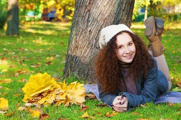 Mulher bonita e elegante deitada em um parque no outono — Fotografia de Stock