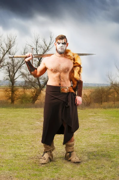 Retrato de um antigo guerreiro musculoso com uma espada — Fotografia de Stock