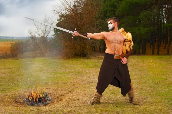 Retrato de um antigo guerreiro musculoso com uma espada — Fotografia de Stock