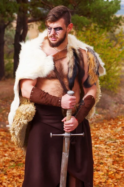 Portrait of a muscular ancient warrior with a sword — Stock Photo, Image