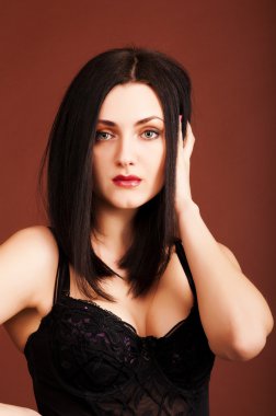 Kahverengi zemin üzerine siyah elbiseli esmer kadın