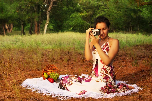 Morena bela mulher com câmera em um prado — Fotografia de Stock