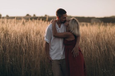 Evli çift yaz günbatımında sarılıp öpüşüyor. 