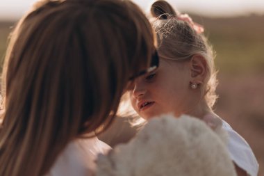 Anne ve kızı lavantada sarılıyorlar ve doğada eğleniyorlar.