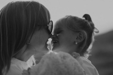 Anne ve kızı lavantada sarılıyorlar ve doğada eğleniyorlar.