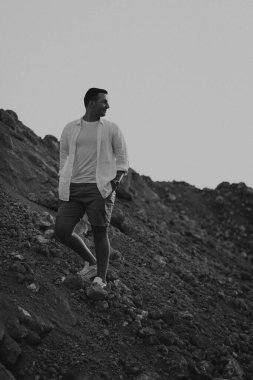 Yakışıklı adam gün batımında dışarıda yürüyor.