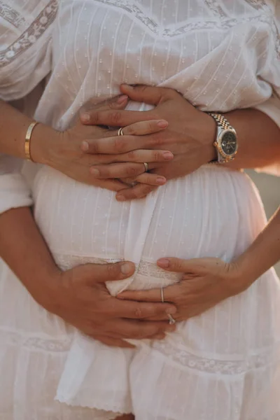 在野外 怀孕妇女和丈夫抱着肚子在一起 — 图库照片