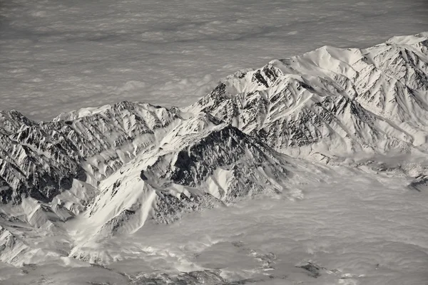 Vista das montanhas cobertas de neve do avião — Fotografia de Stock
