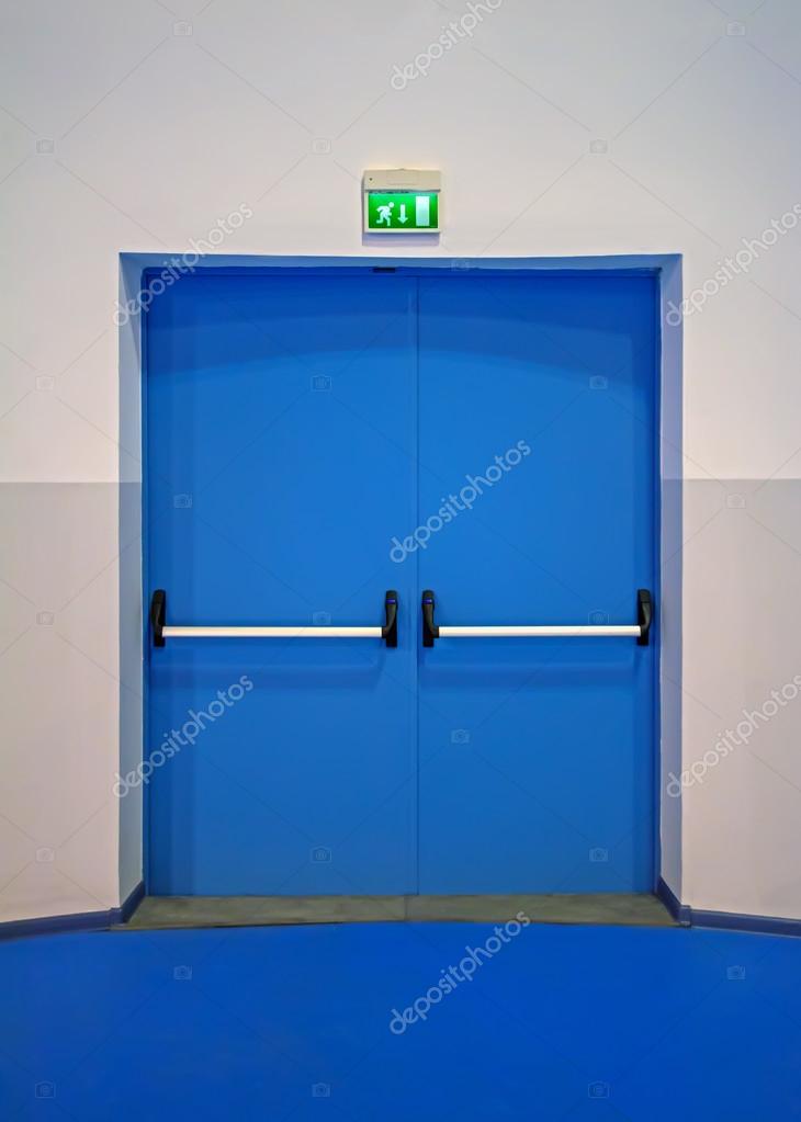 Blue door of gym with exit sign above them — Stock Photo © artavet